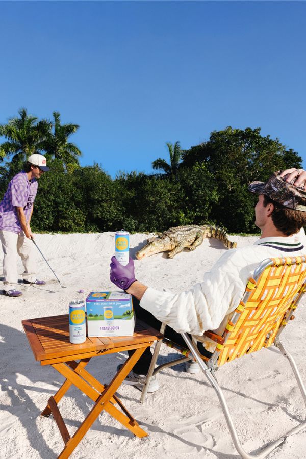 Man sitting on the beach with the new High Noon Transfusion in his hand